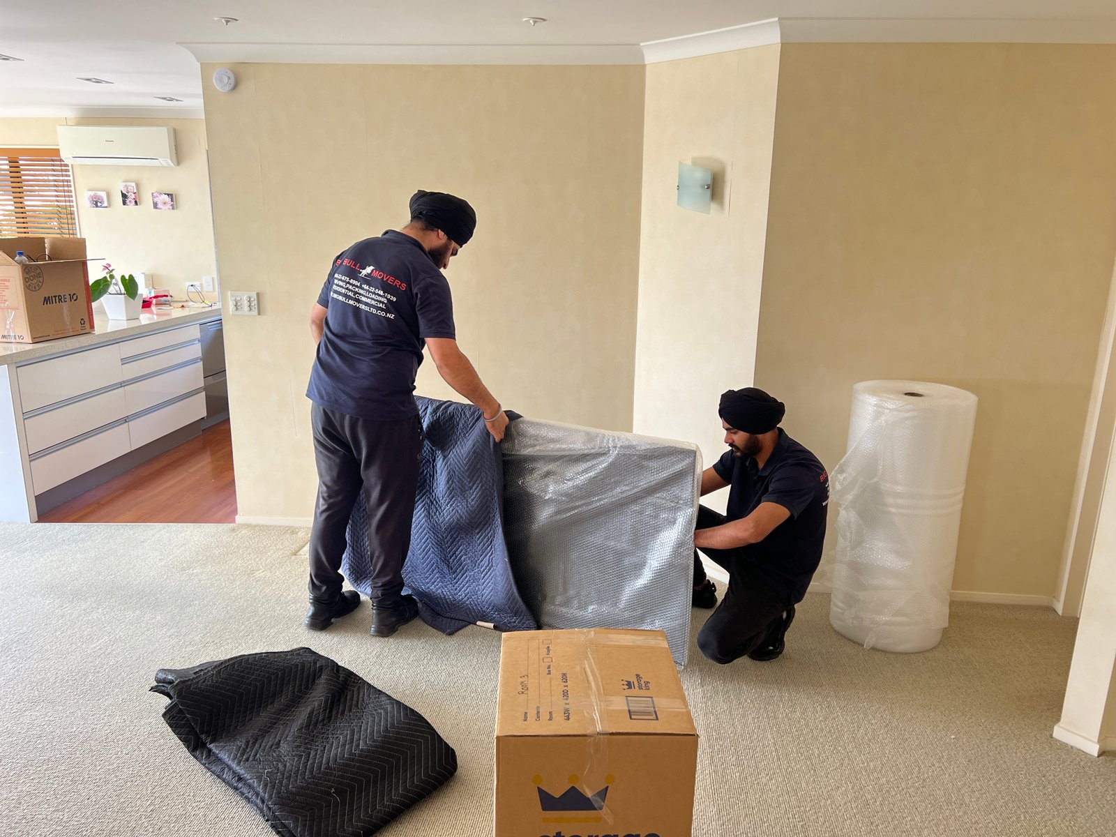 Big Bull Movers team protecting furniture with moving blankets and bubble wrap in Auckland